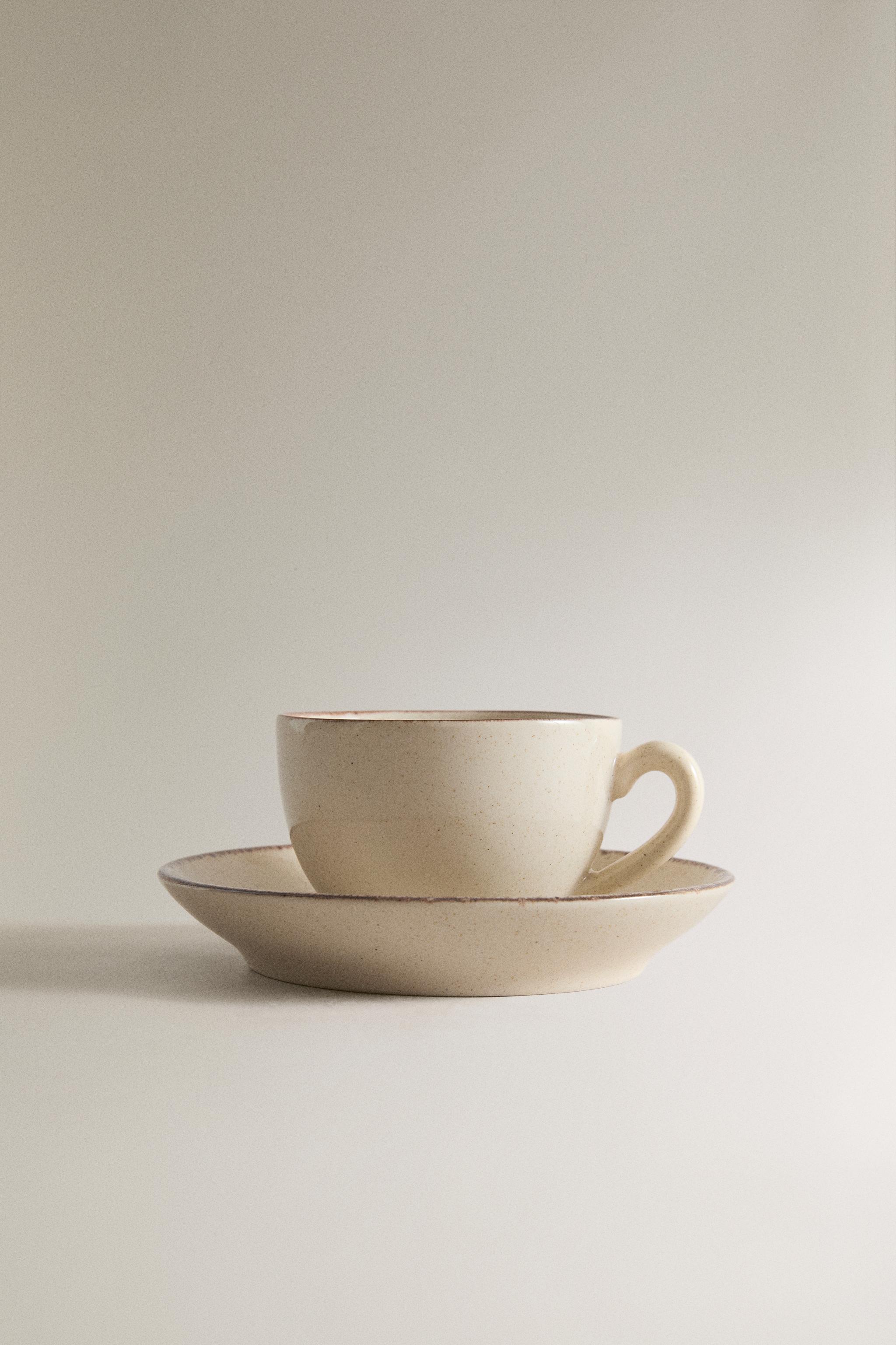 STONEWARE TEACUP AND SAUCER WITH DISTRESSED RIM